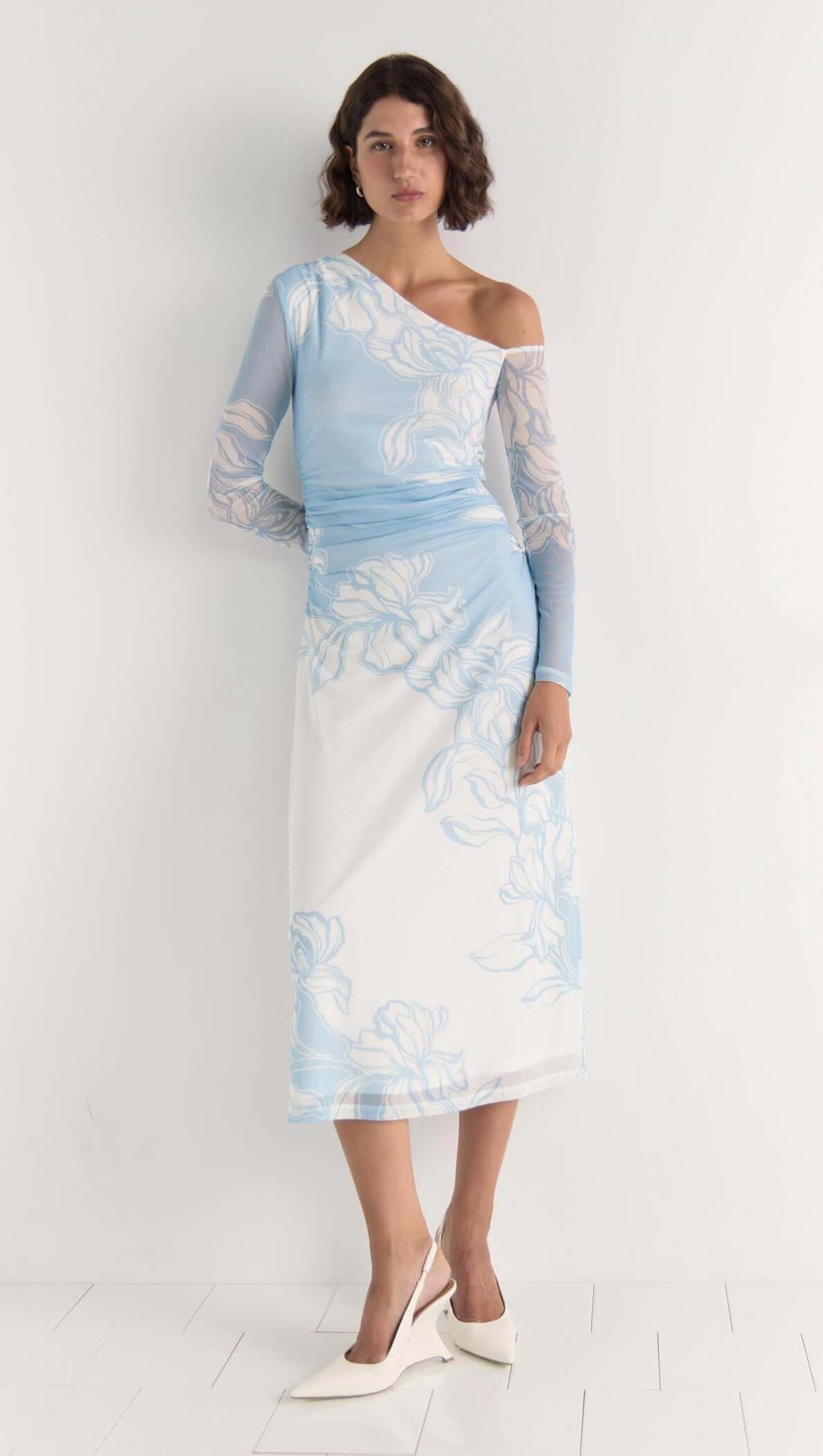 Model wearing the Aurora Mesh Midi Dress in sky blue floral mesh with one-shoulder neckline and side ruching.