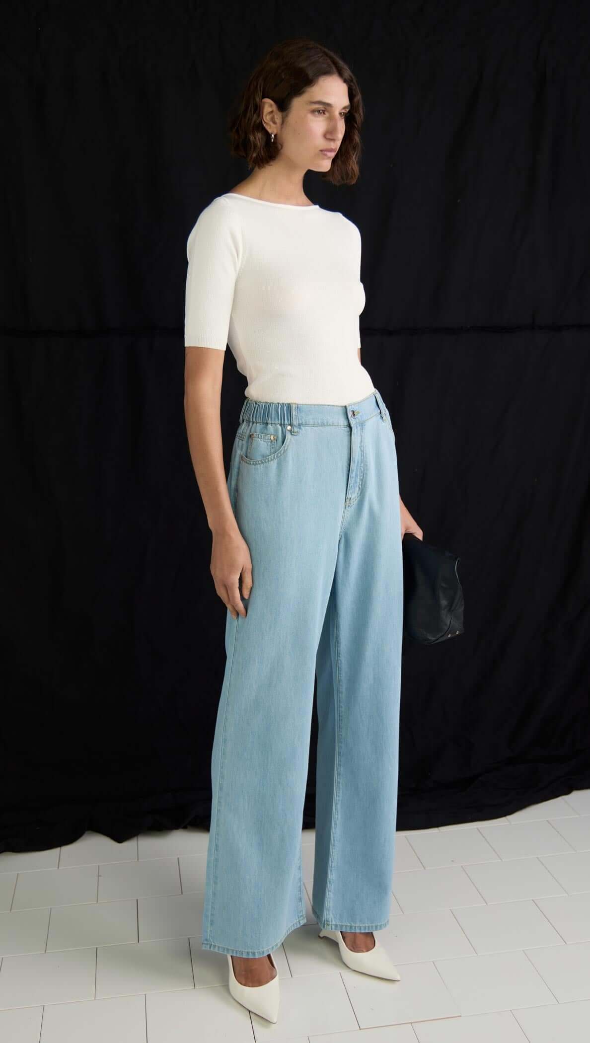 Model wearing Amelia Chambray Jeans in light blue, showcasing wide-leg silhouette and elasticated back waistband.