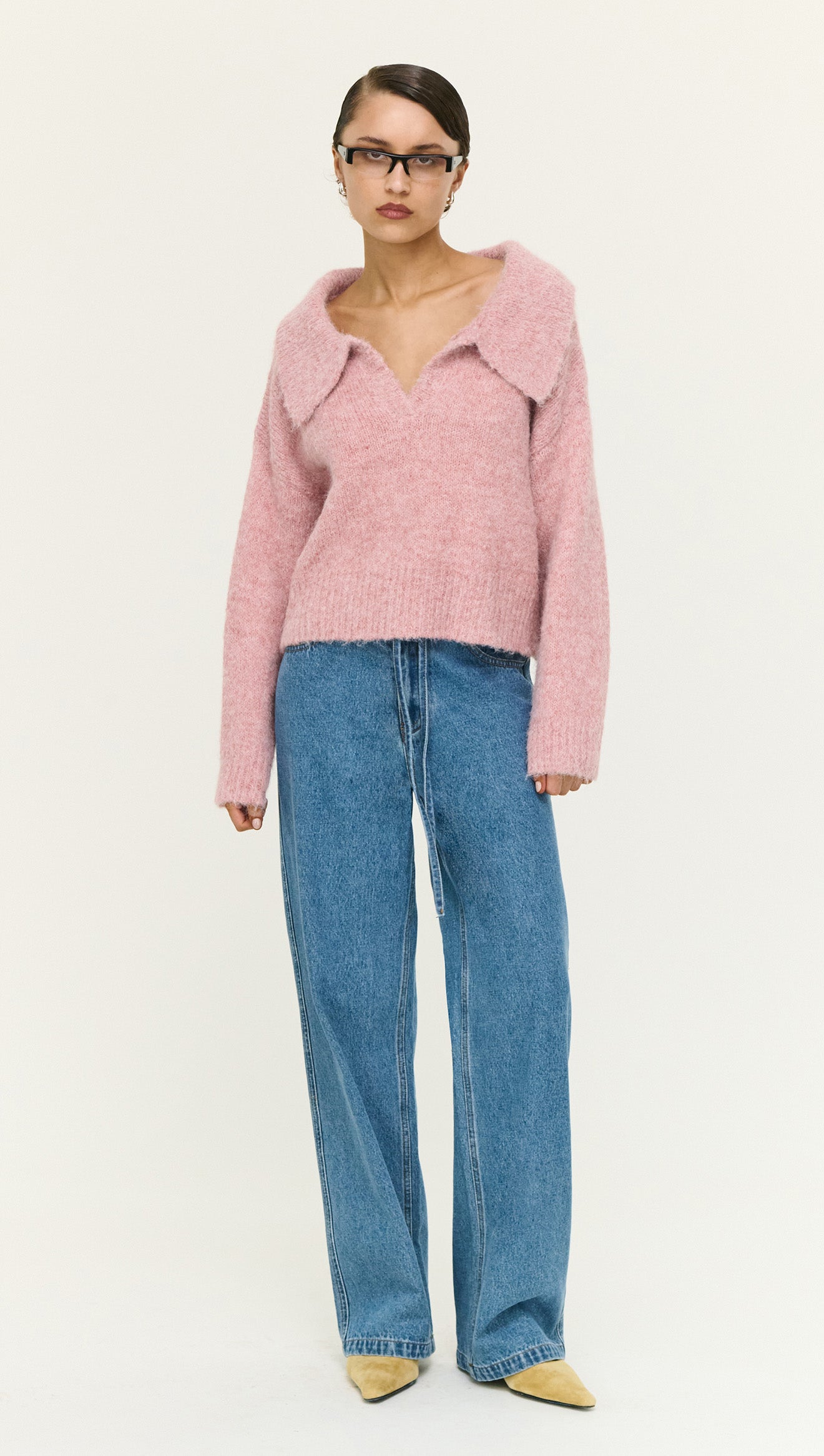 Model wearing a Dusky Pink Fluffy Knit Polo Jumper paired with high-waisted jeans and stylish heels, front view.