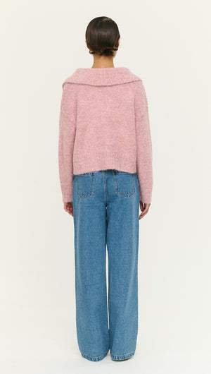 Back view of a model wearing a Dusky Pink Fluffy Knit Polo Jumper paired with wide-leg jeans.