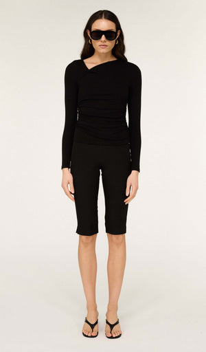 Model wearing Mid Rise Capri Pants in Black with a stylish long-sleeve top and sunglasses, showcasing a chic outfit.