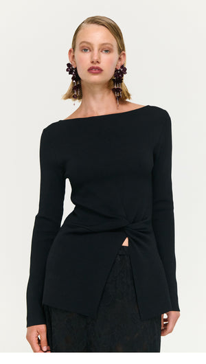 Model wearing a Black Boat Neck Twist Knit Top, showcasing a stylish twist knot detail and modern design.