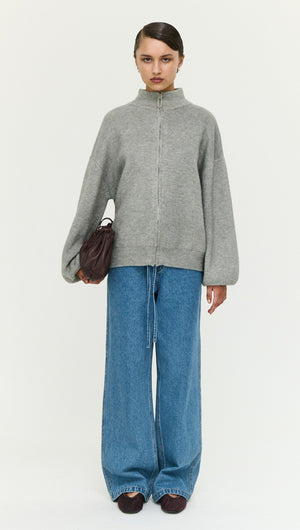 Model wearing Soft Grey Oversized Zip Cardigan with wide-leg jeans and a small handbag.