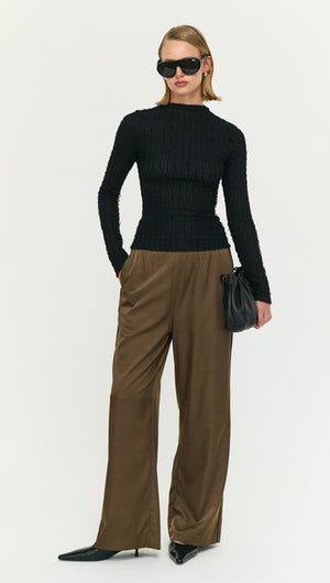 Model wearing a Black High Neck Crinkle Stitch Top paired with relaxed trousers and sunglasses.