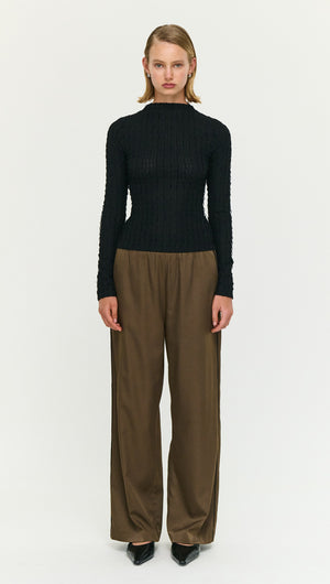 Model wearing a Black High Neck Crinkle Stitch Top paired with wide-leg trousers, showcasing an elegant layered look.