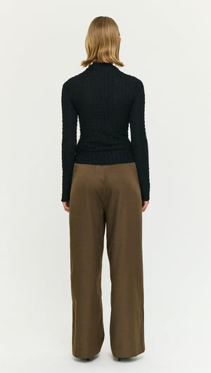 Model wearing the Black High Neck Crinkle Stitch Top with wide-leg trousers, viewed from the back.