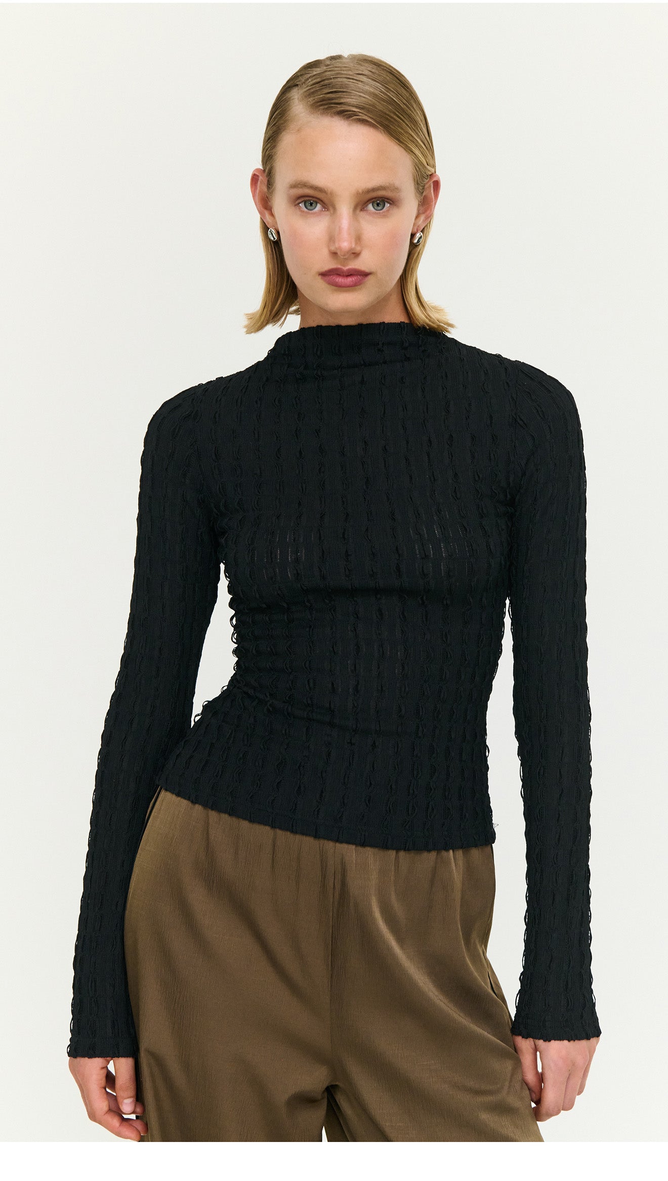 Model wearing a Black High Neck Crinkle Stitch Top, showcasing its textured fabric and stylish design.