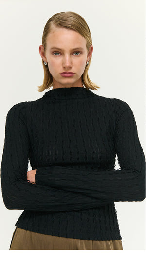 Model wearing a Black High Neck Crinkle Stitch Top, showcasing its textured fabric and stylish design.