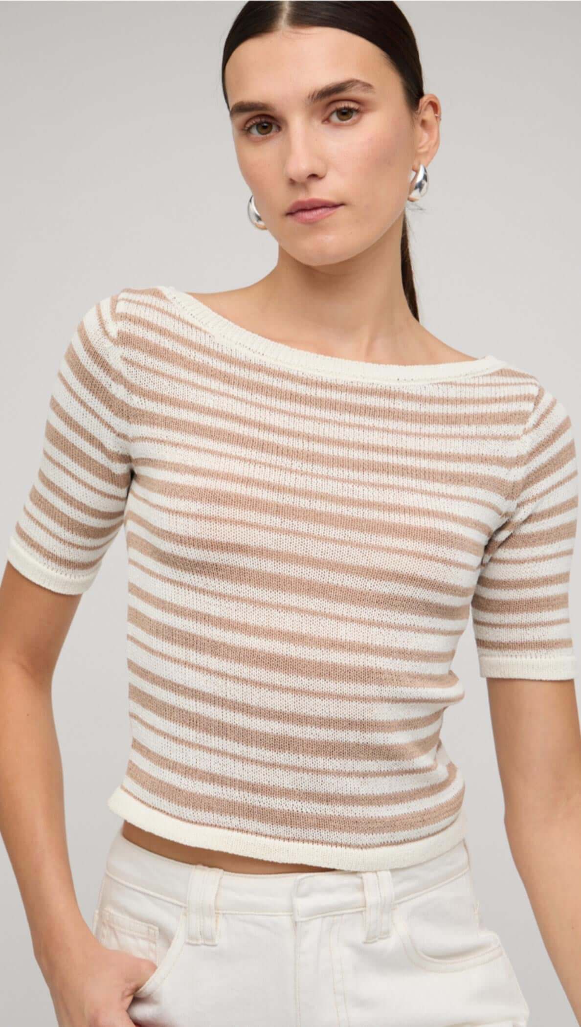Beige and white striped boat neck knit top featuring short sleeves, styled with white pants.