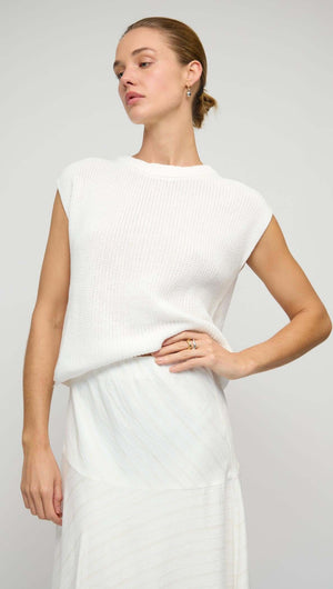 Woman wearing a stylish top with the Asymmetric White Bias Maxi Skirt, showcasing a fashionable outfit combination.