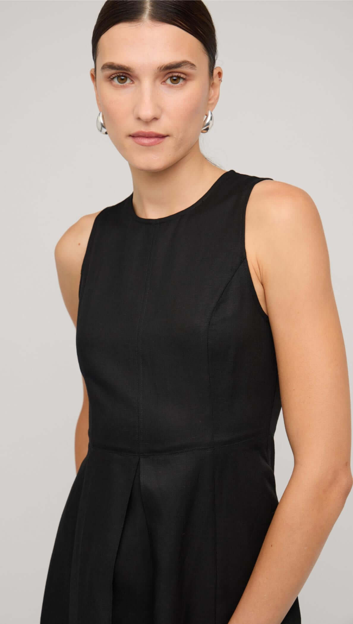 Model wearing a black linen A-line midi dress, showcasing a sleek design with a fitted bodice and flared skirt.