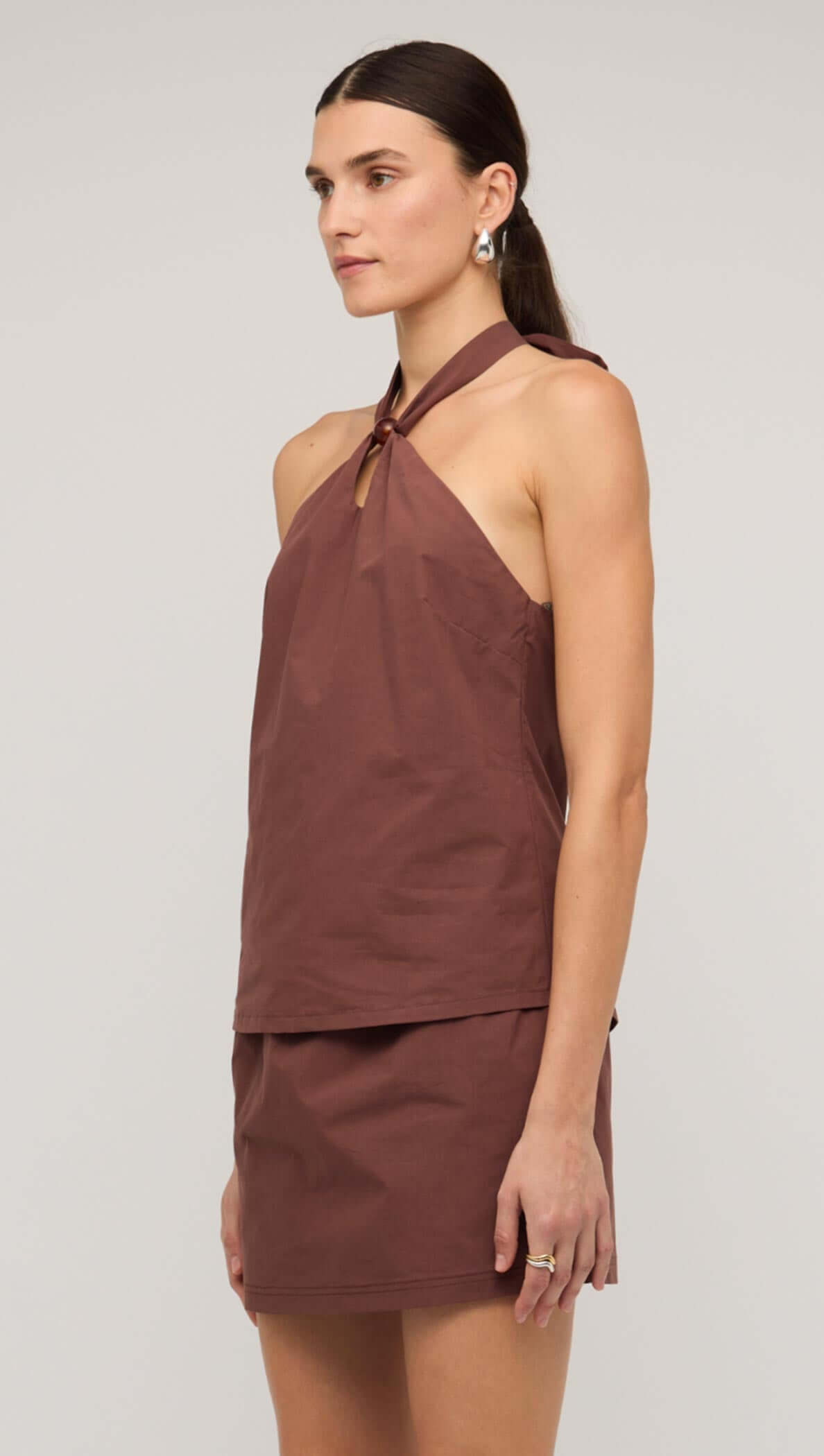 Brown cotton halter-neck top with knot detail, perfect for stylish summer outfits.