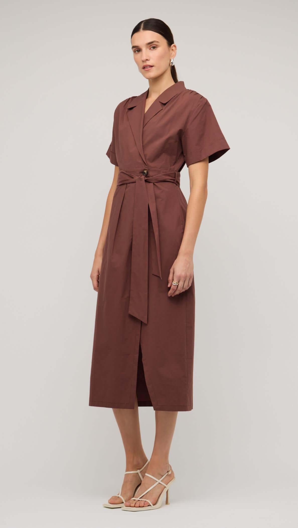 Model wearing a brown cotton wrap midi shirt dress with short sleeves and a belted waist.