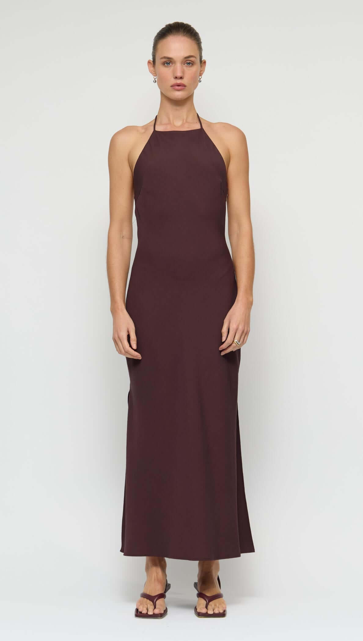 Elira Chocolate Halter Midi Dress featuring halter neckline, open back, and side split for a modern, sophisticated look.