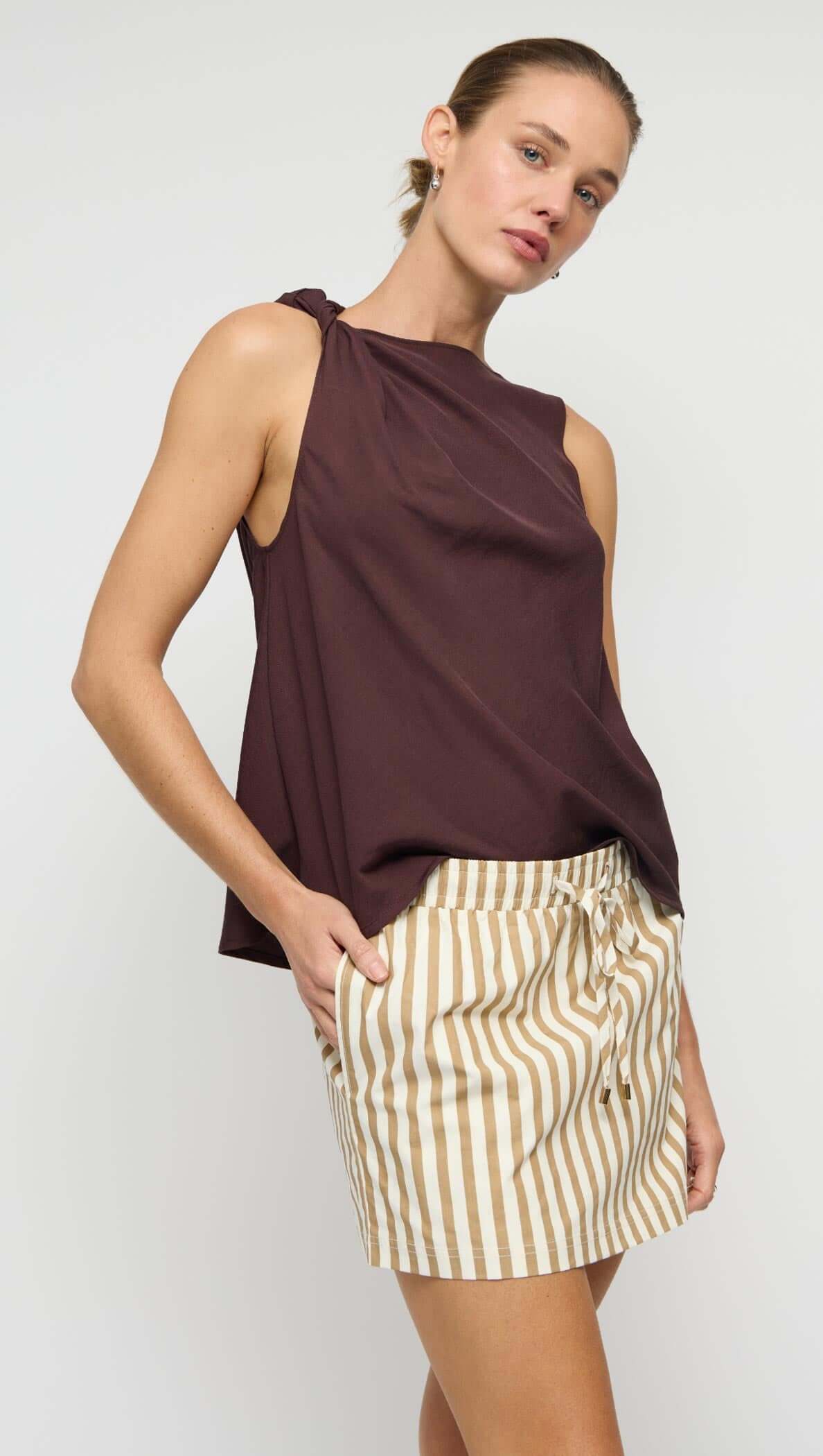 Model wearing Chocolate Twist Top with shoulder knot detail and striped shorts, showcasing relaxed styling.