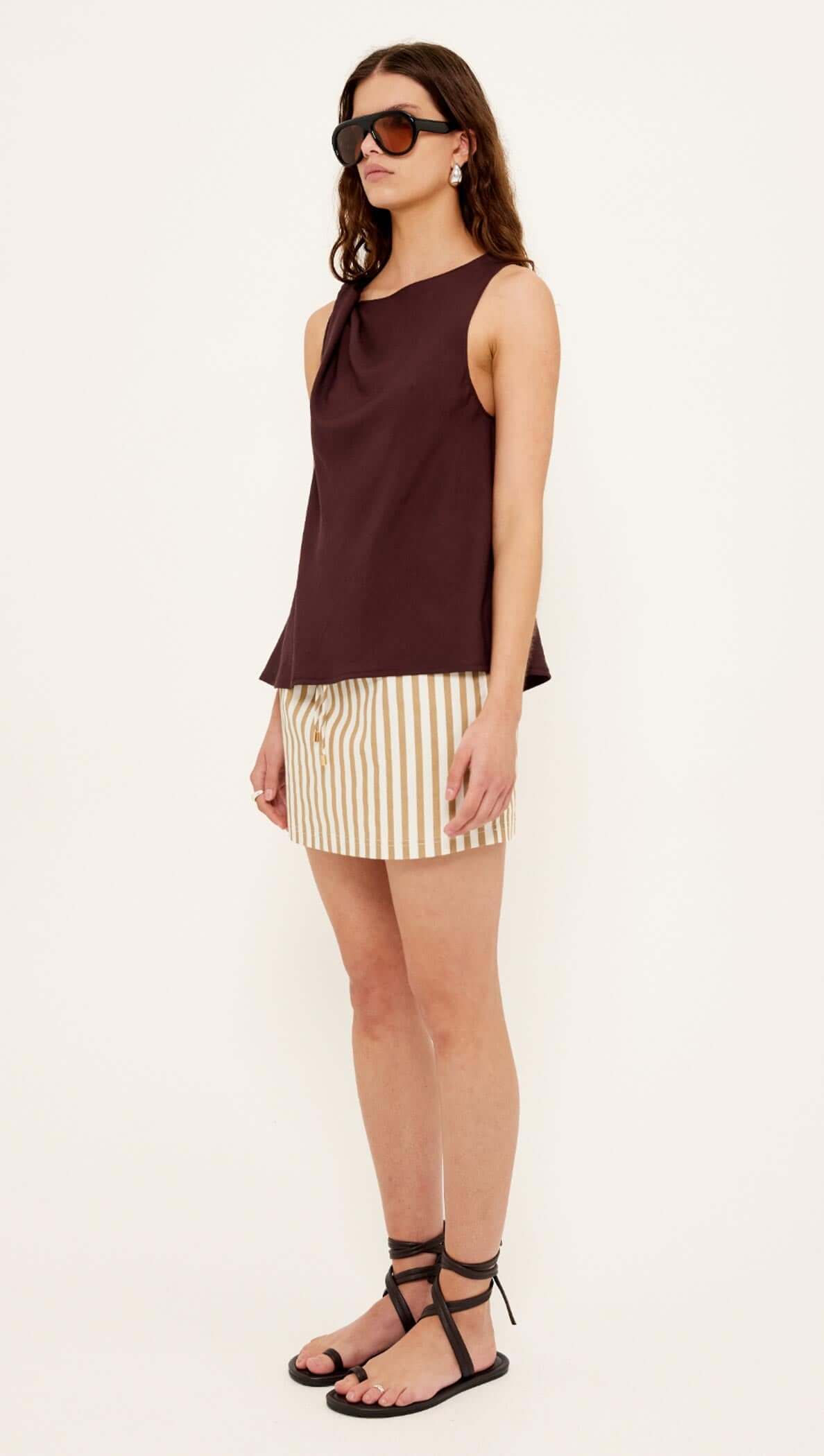 Model wearing the Chocolate Twist Top with shoulder knot detail and striped shorts, showcasing a relaxed summer look.