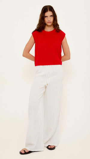 Cotton Blend Red Knit Tank Top worn with white wide-leg pants, featuring a relaxed fit and modern silhouette.