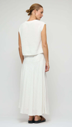 Back view of model wearing a Cotton Blend White Knit Tank Top paired with a flowing skirt.