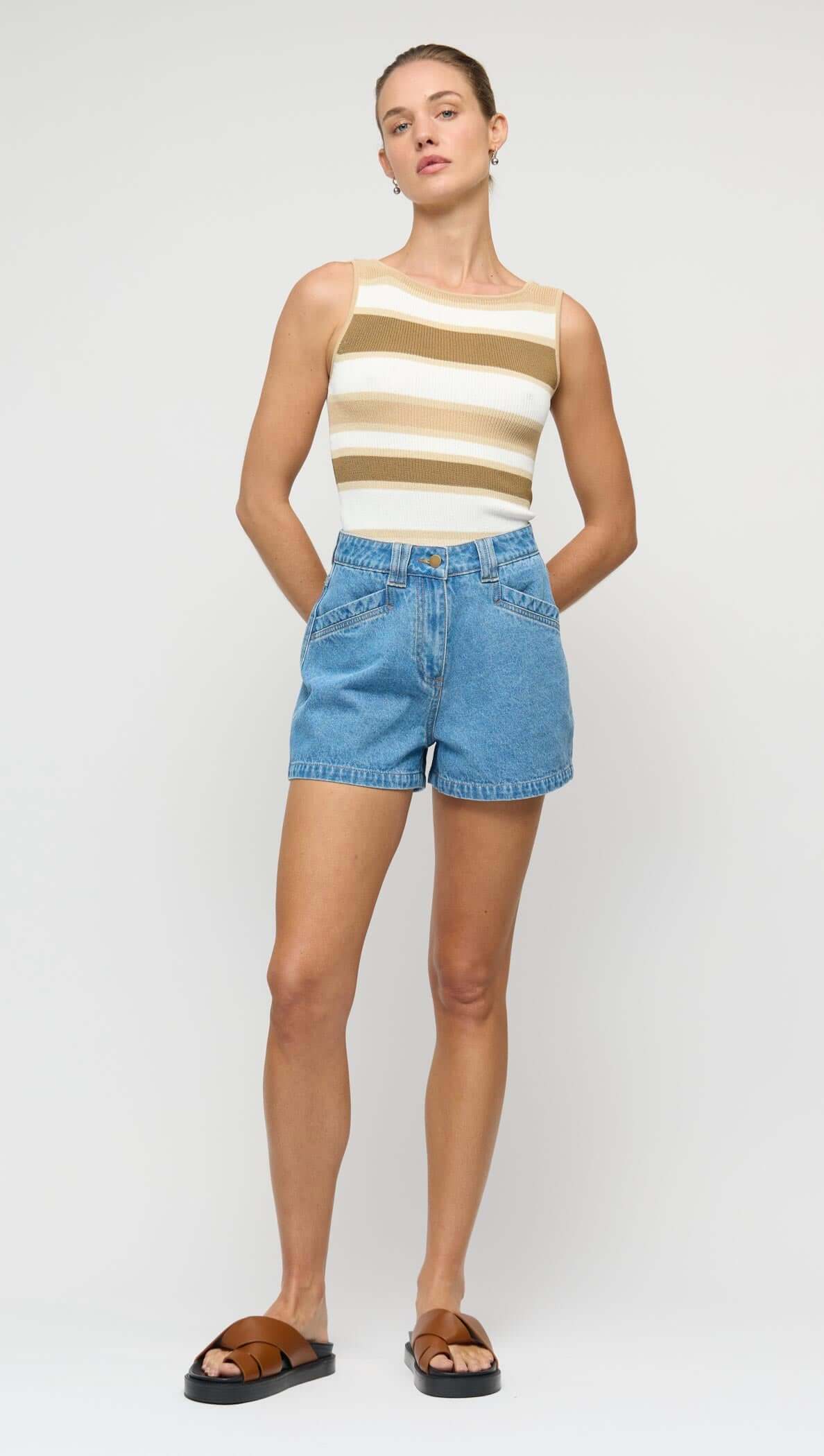 Model wearing NOA DENIM SHORTS paired with a striped sleeveless top and sandals, styled for a casual look.