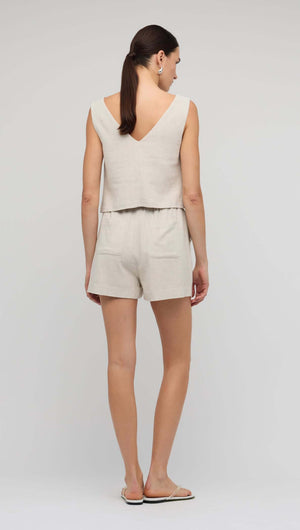 Back view of a model wearing the Natural Marle V-Back Linen Top paired with matching shorts.