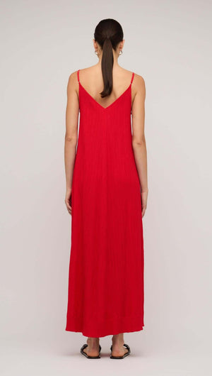 Back view of a woman wearing a red crepe V-neck floaty maxi dress, showcasing its elegant design and flow.