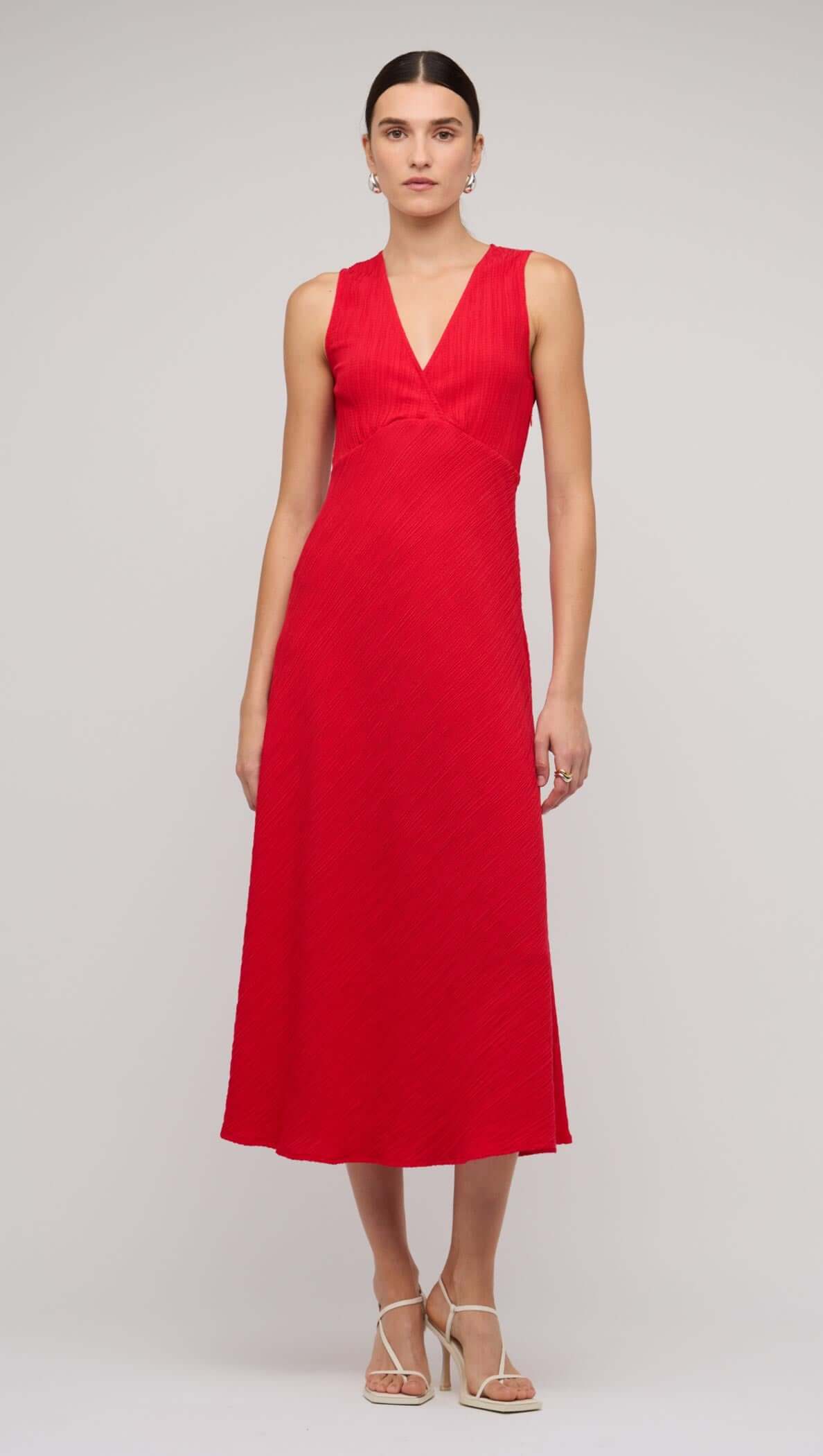 Red V-neck bias midi dress with tie back, showcasing a sleek silhouette and elegant style on a model.