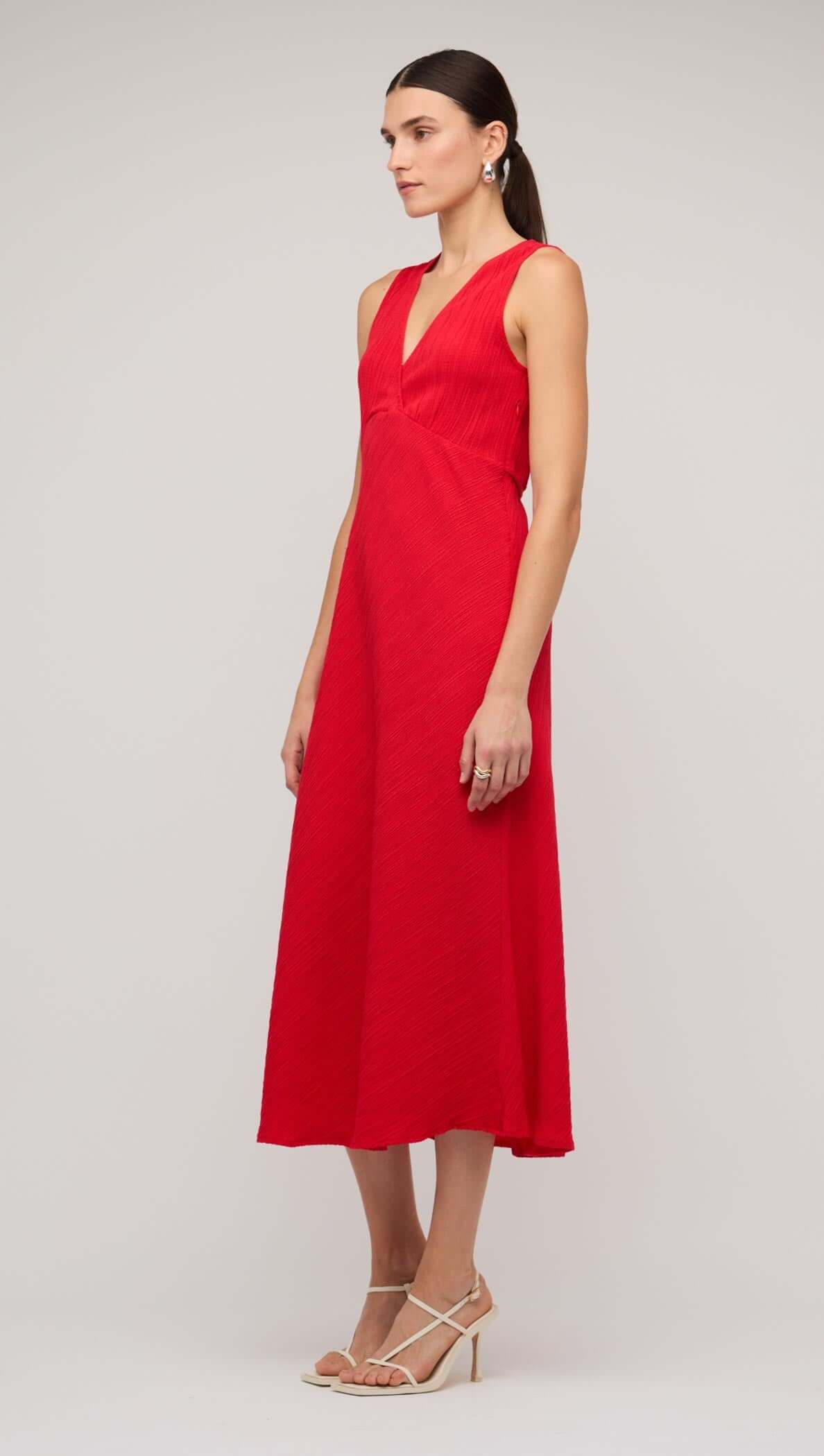 Red V-neck bias midi dress with tie back, showcasing a sleek silhouette and elegant style on a model.