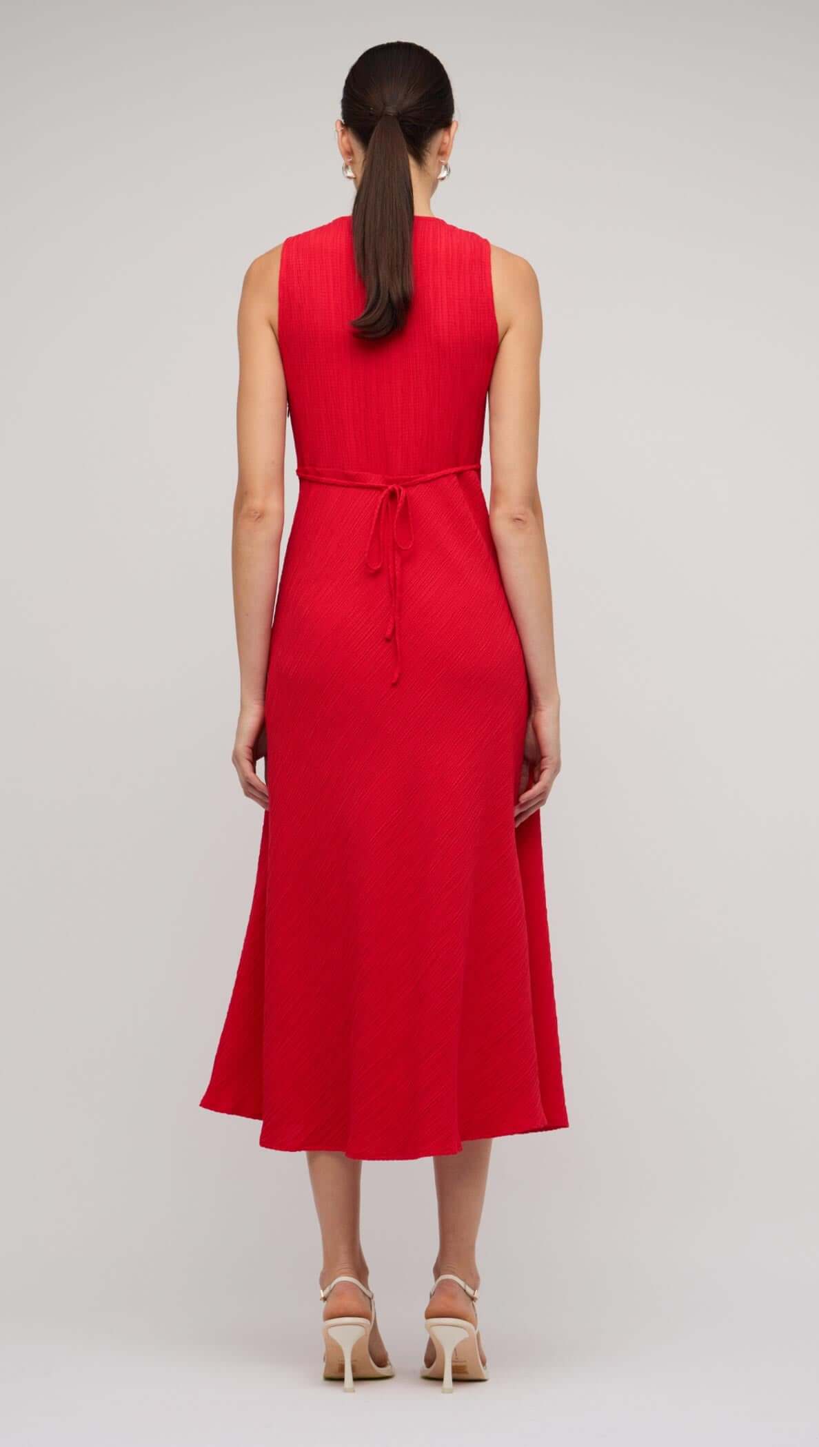 Back view of a stylish red V-neck midi dress with a tie-back detail and flared hem, perfect for summer occasions.