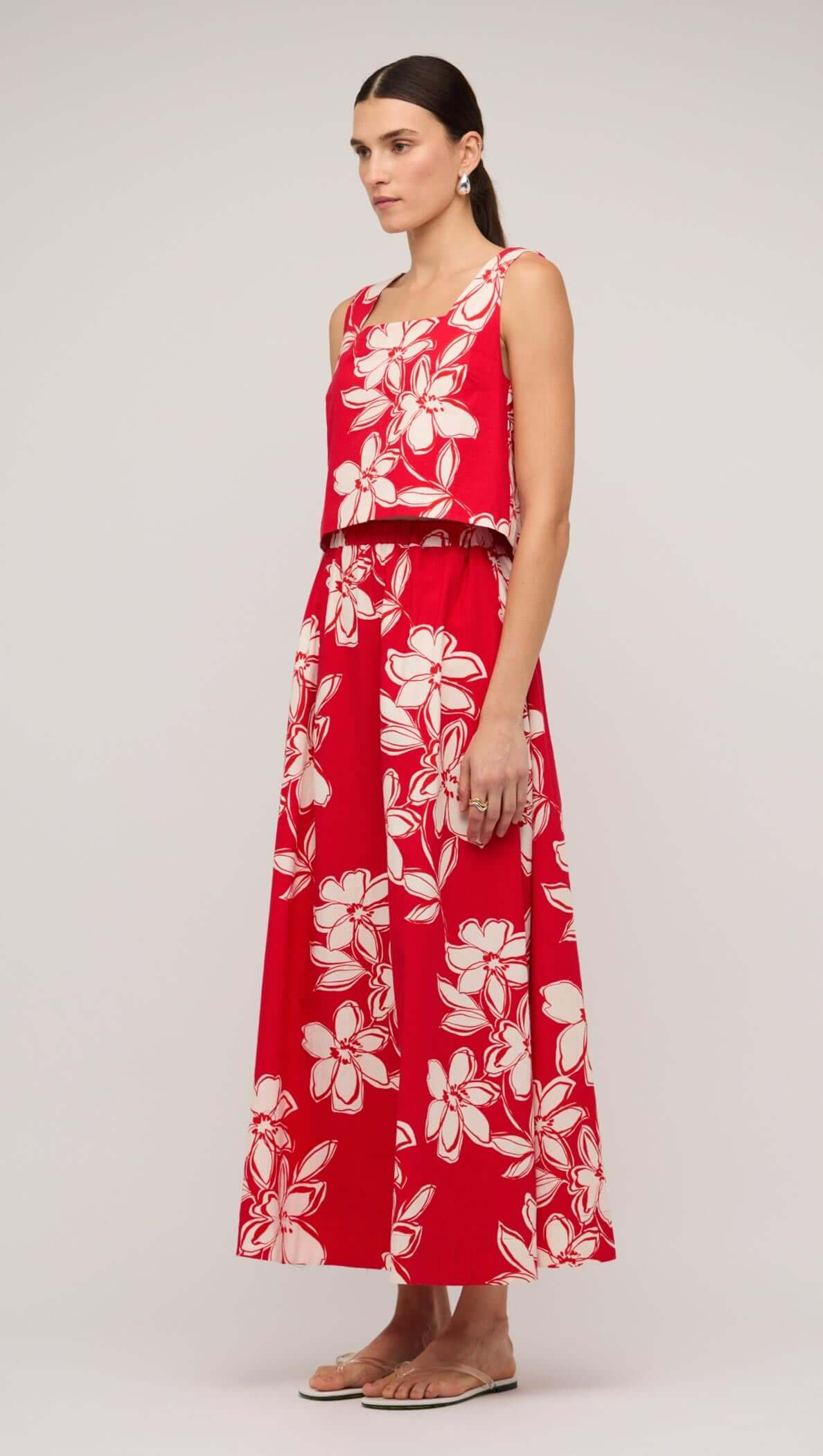 Model wearing a red and white cotton floral A-line maxi skirt with a matching cropped top, perfect for summer outings.
