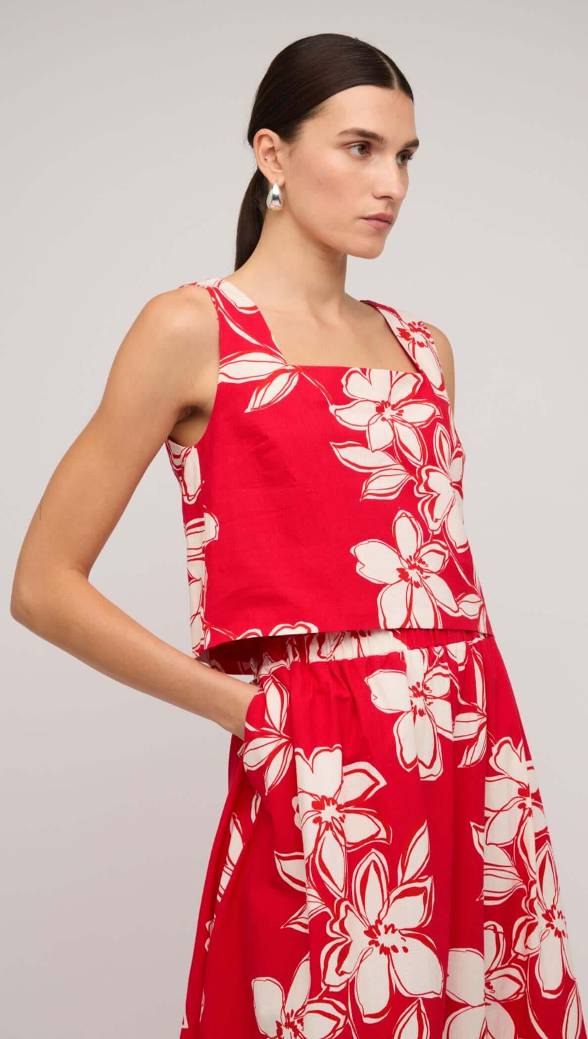 Model wearing a red and white floral crop top with square neckline, styled effortlessly for a fresh summer look.