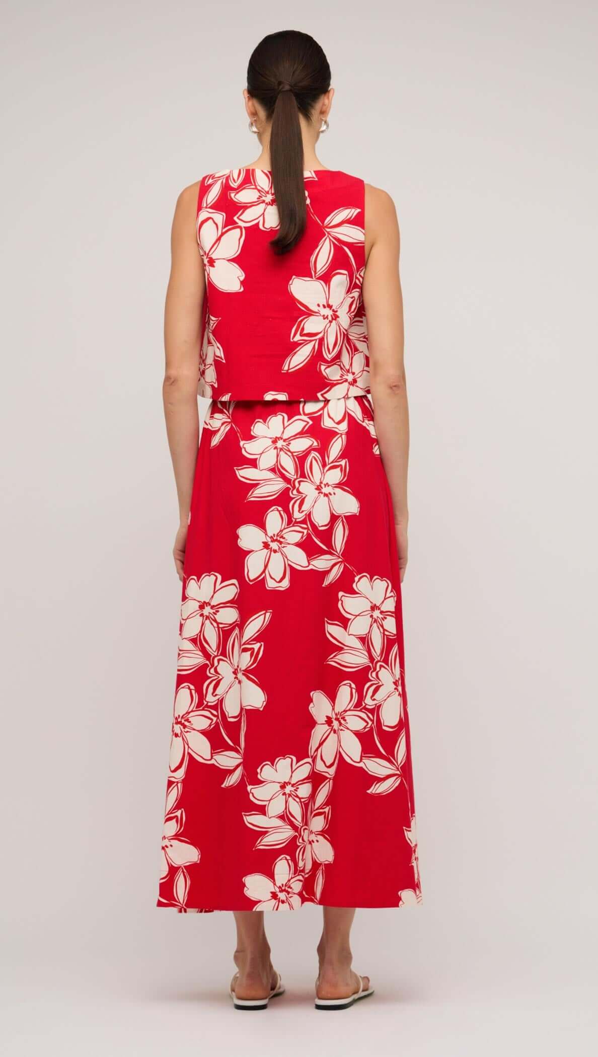 Back view of a woman wearing a red and white floral cotton crop top, showcasing a stylish and breezy summer look.