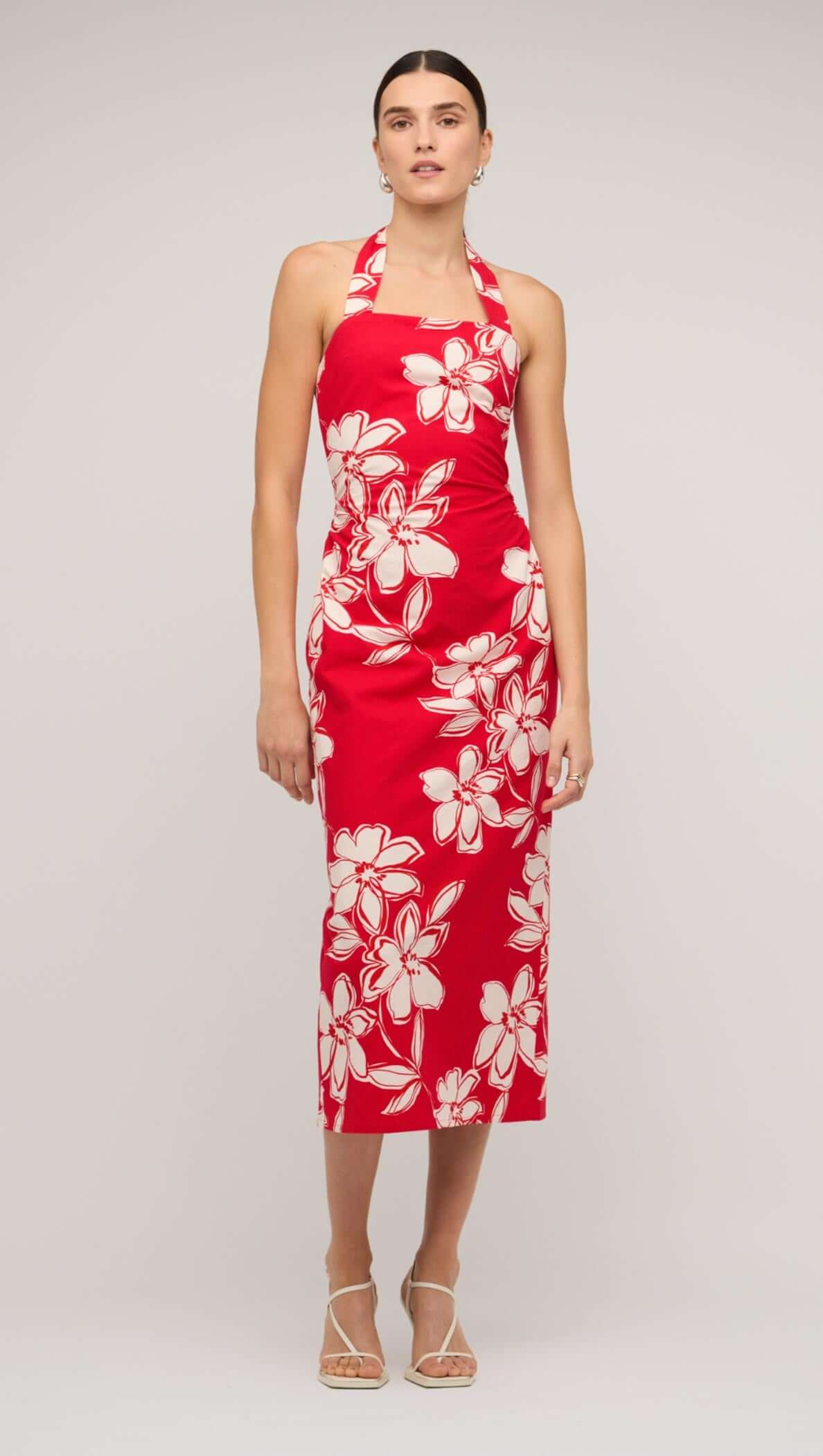 Model wearing a red and white floral halter-neck midi dress against a neutral background.