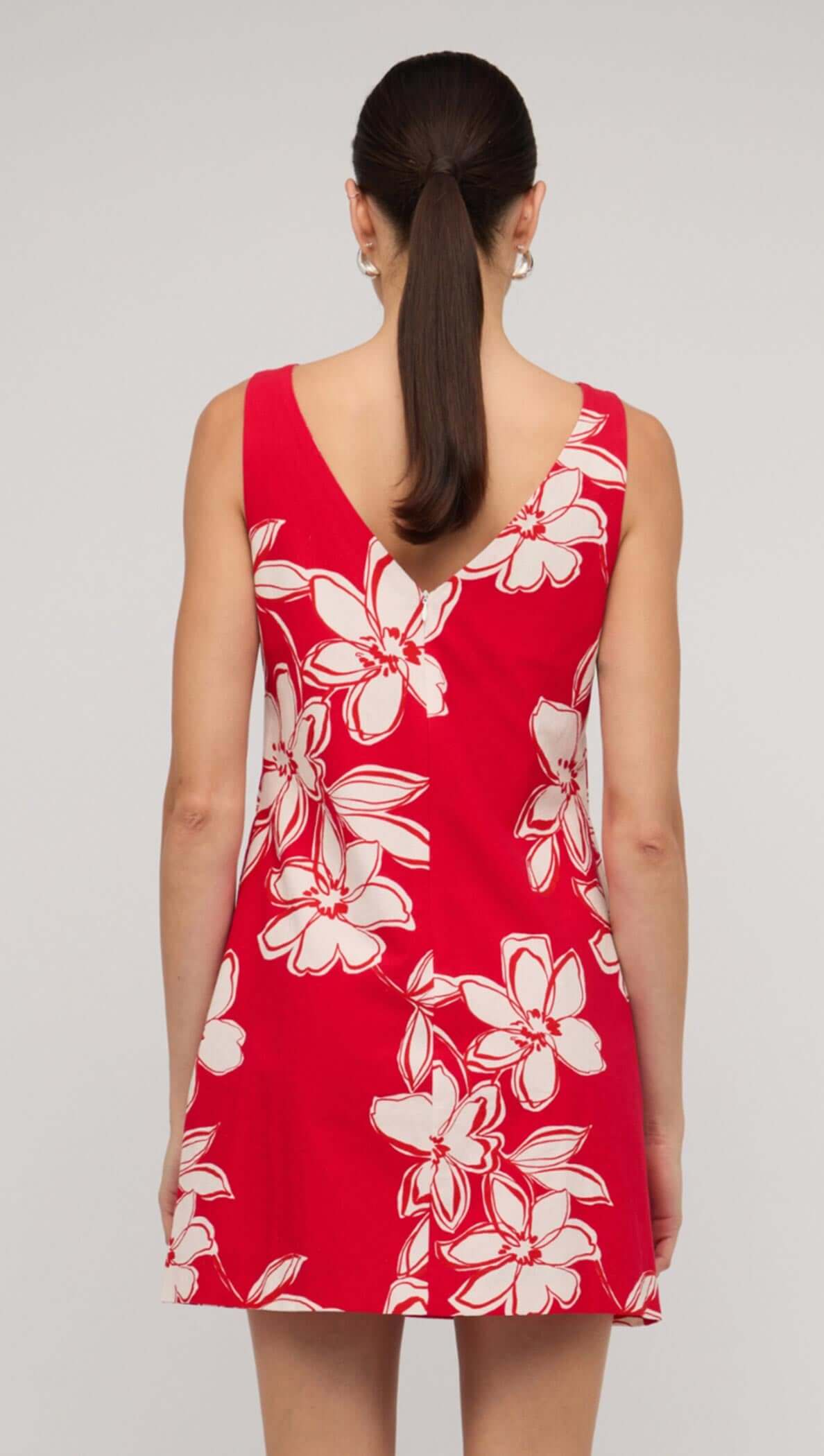 Back view of a red and white floral mini shift dress, showcasing a sleeveless design and a flattering V-neckline.