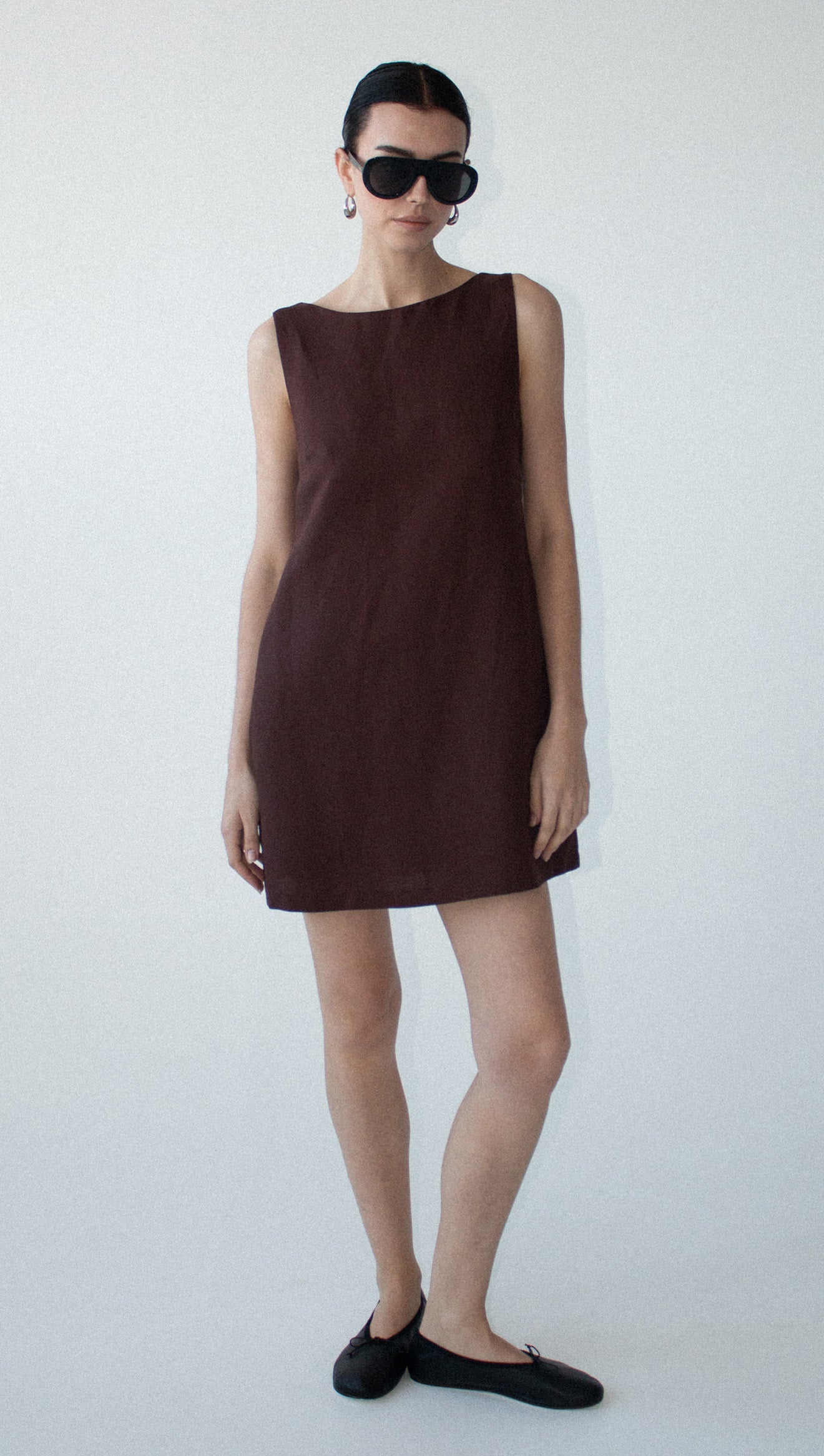 Model wearing a Chocolate Linen Blend Boat Neck Mini Shift Dress, holding flowers, showcasing a chic summer style.