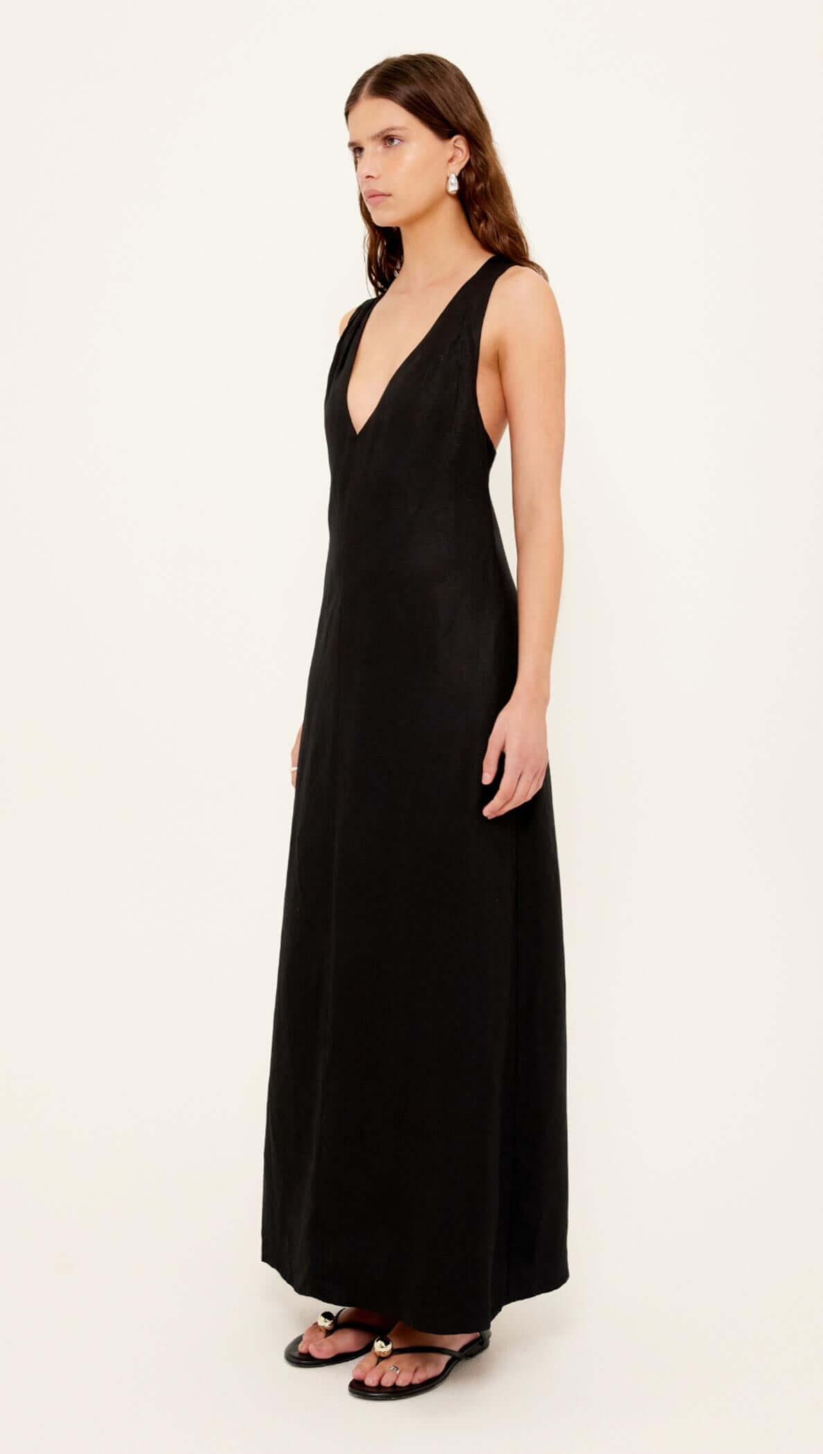 Model showcasing the Black Cross Back V-Neck Maxi Dress, featuring a deep V-neckline and elegant silhouette.