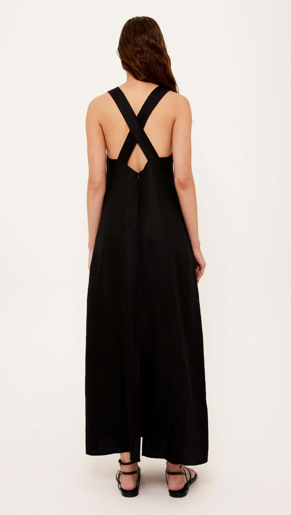 Back view of the Black Cross Back V-Neck Maxi Dress showcasing cross-back straps and a flowing silhouette.