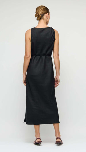 Back view of a woman wearing a Linen Blend Black Midi Dress with Tie Waist, showcasing its relaxed fit and drape.