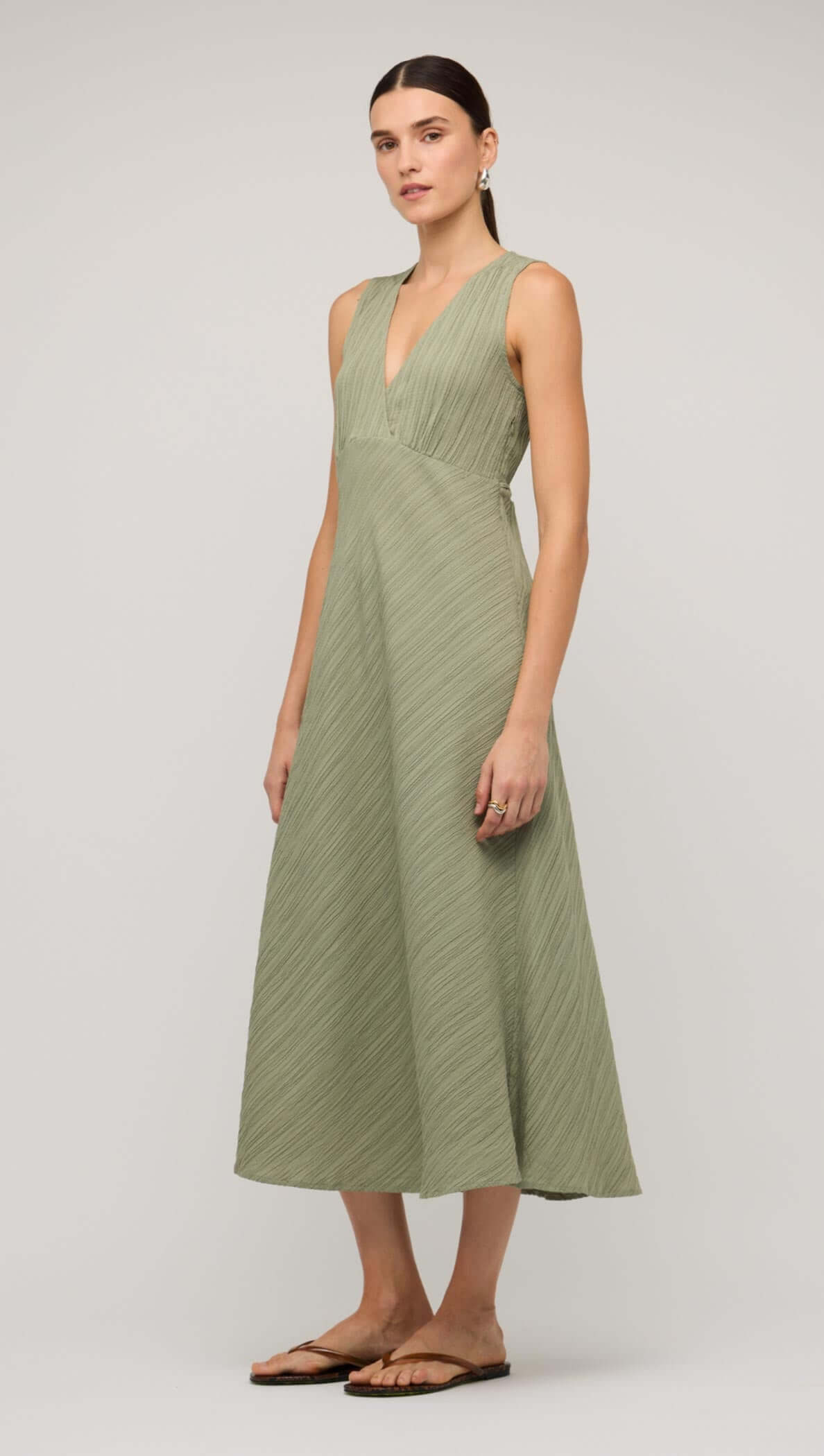 Sage green V-neck bias midi dress featuring a flowy design, perfect for casual and elegant occasions.