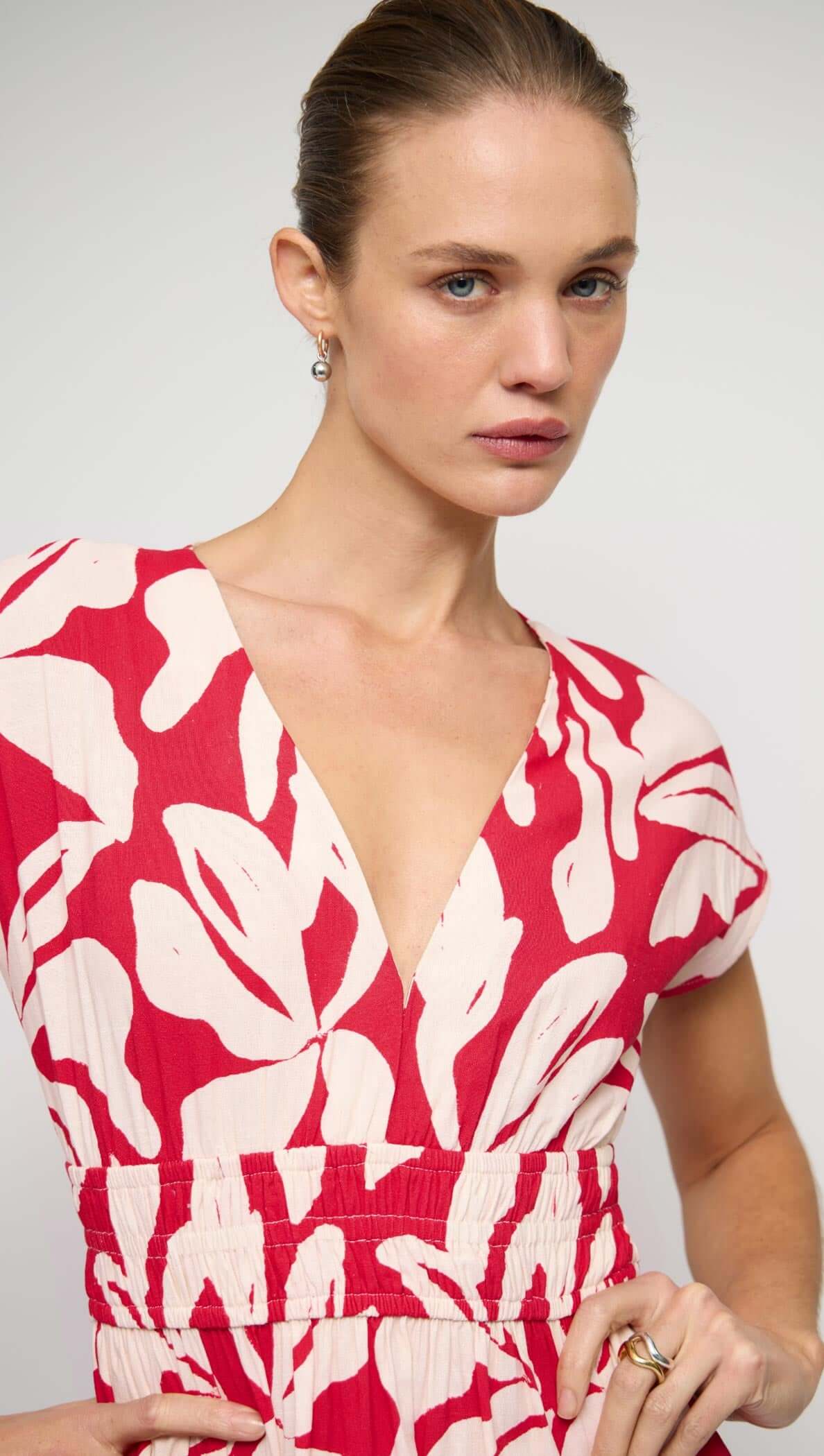 Cotton Blend Red & White Floral Print Shirred Midi Dress modeled by a woman with a deep V neckline and shirred waist.