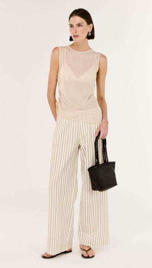 Woman wearing a Sheer Drawstring Knit Tank Top paired with striped wide-leg pants, holding a black tote bag.