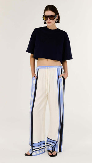 Model wearing Stripe Relaxed Wide-Leg Low Rise Pants with a navy crop top and oversized sunglasses, showcasing a relaxed style.