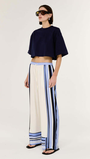 Model wearing Stripe Relaxed Wide-Leg Low Rise Pants with a cropped top and sunglasses, showcasing stylish side stripes.