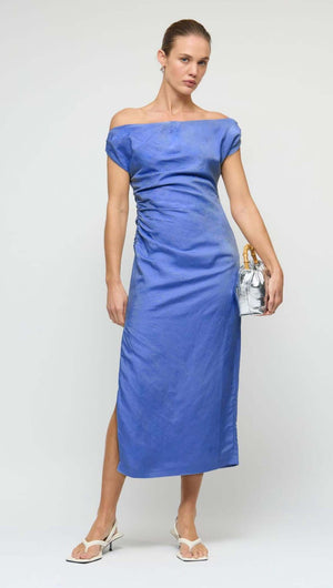 Model wearing a Jacaranda Tencel Linen Blend Off-Shoulder Midi Dress in blue, showcasing draped neckline and flattering fit.