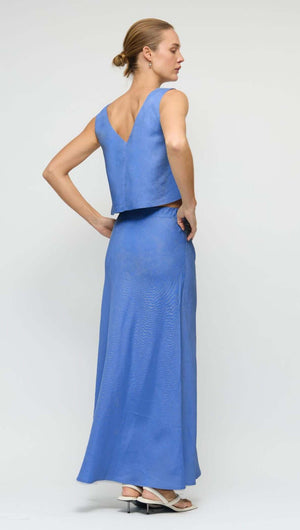 Model wearing the Jacaranda Tencel Linen Blend Top paired with a long skirt, showcasing a back view in a vivid hue.