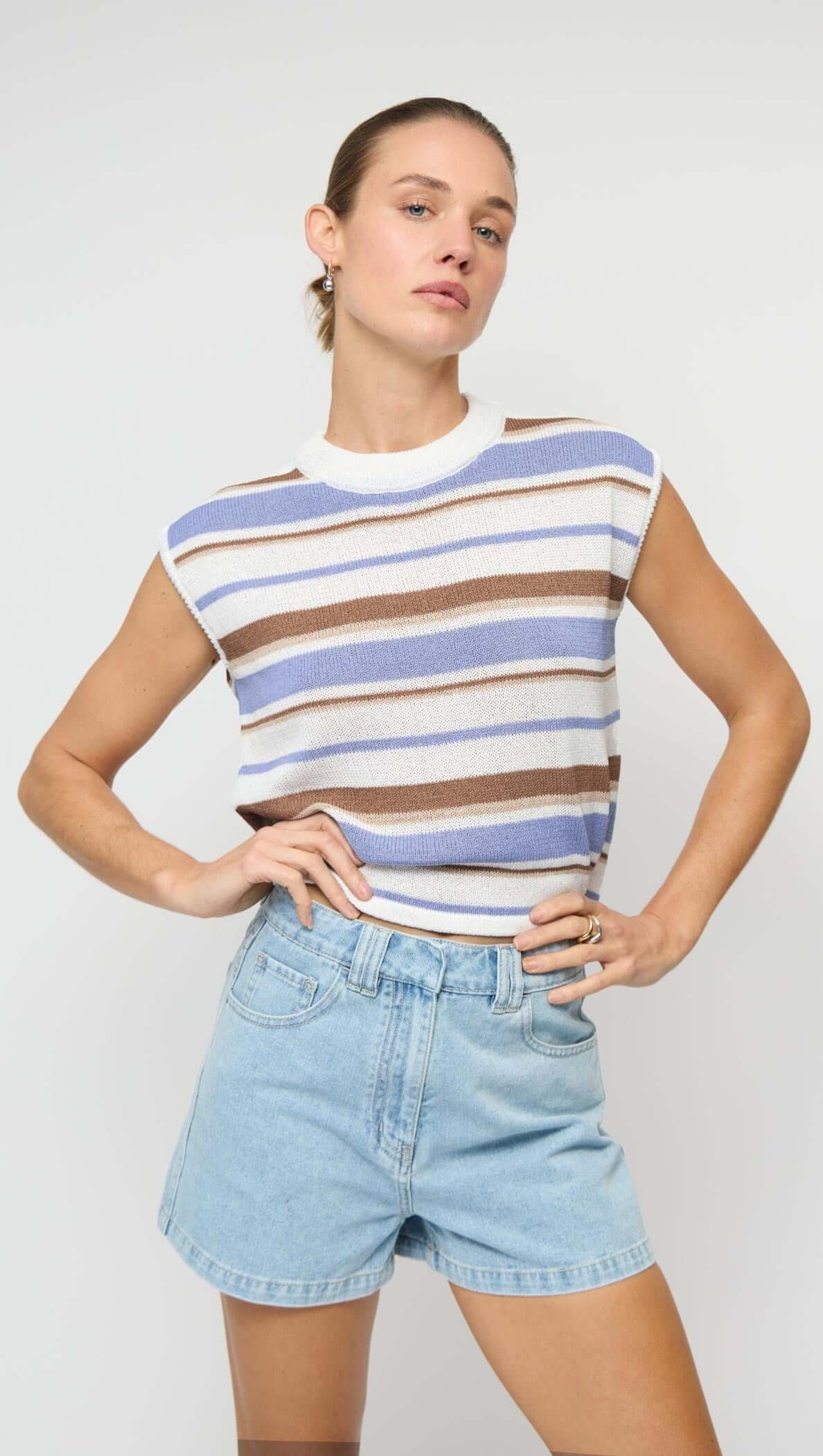 Model wearing Striped Knit Tank Top with blue, brown, and cream stripes paired with denim shorts.