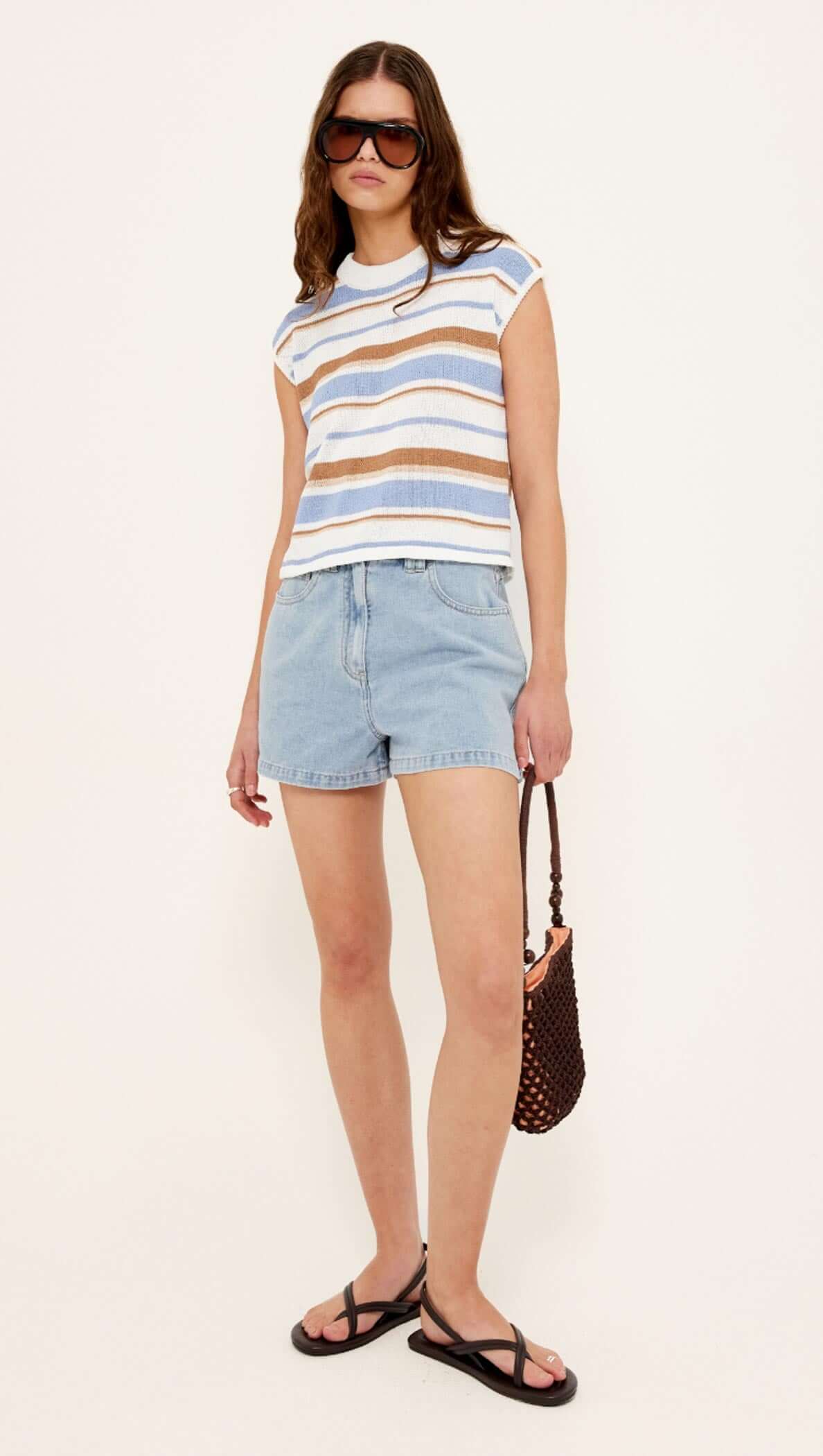 Model wearing Striped Knit Tank Top with denim shorts and sunglasses, showcasing a stylish summer outfit.