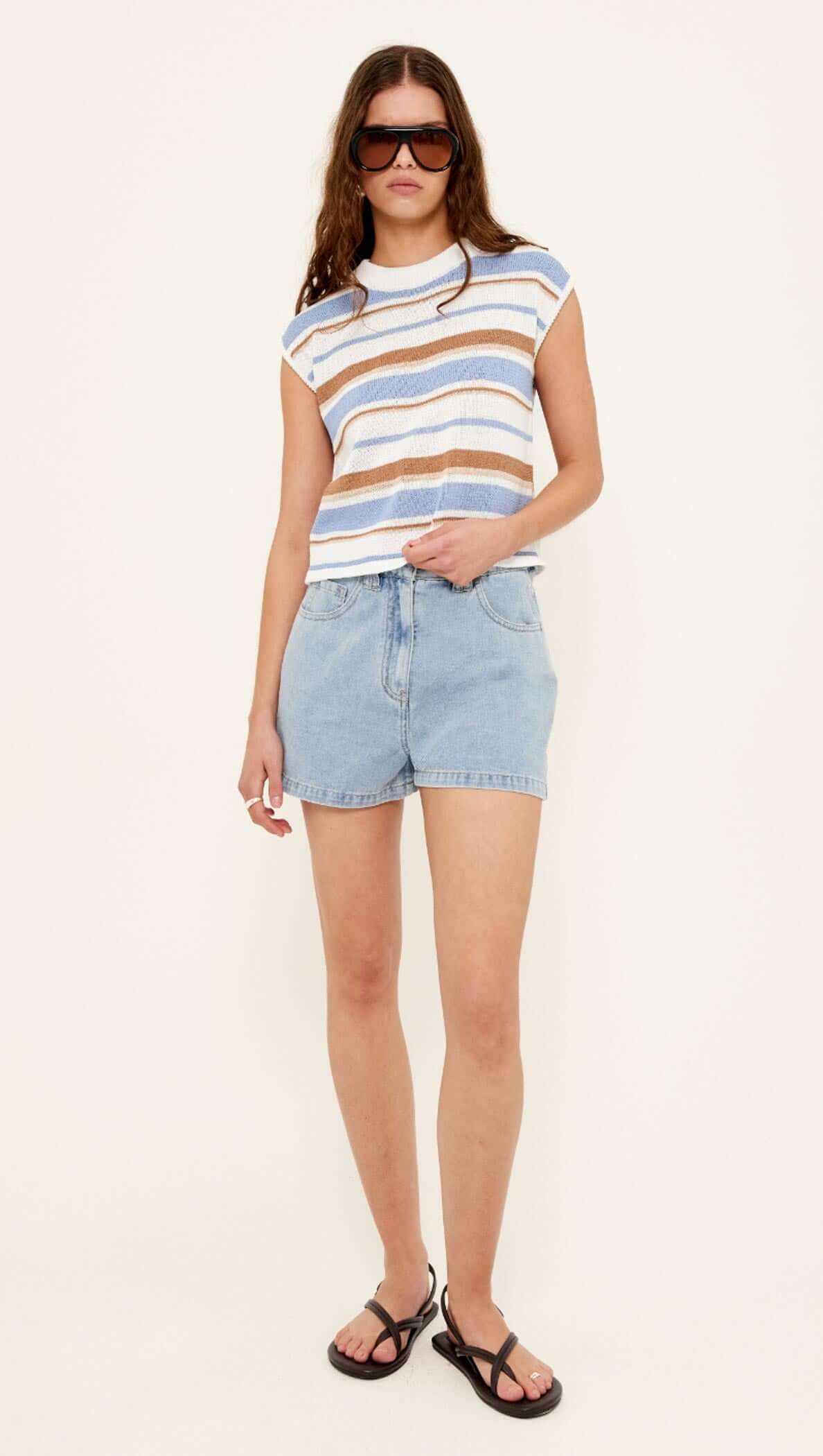 Model wearing a Striped Knit Tank Top paired with denim shorts and black sandals.