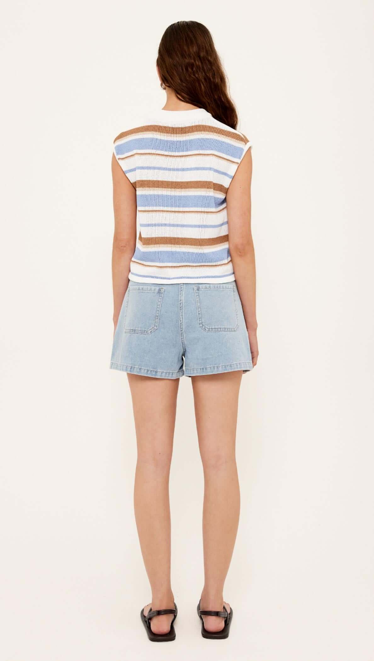 Back view of a woman wearing a Striped Knit Tank Top paired with denim shorts.