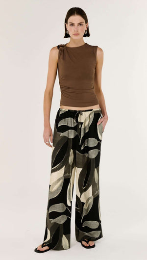 Model wearing a Brown Ruched Slinky Tank with wide-leg patterned pants, showcasing a stylish outfit.