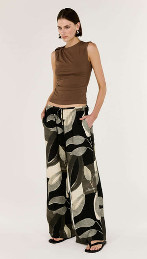 Brown Ruched Slinky Tank styled with patterned wide-leg pants, showcasing modern design and statement hardware detail.